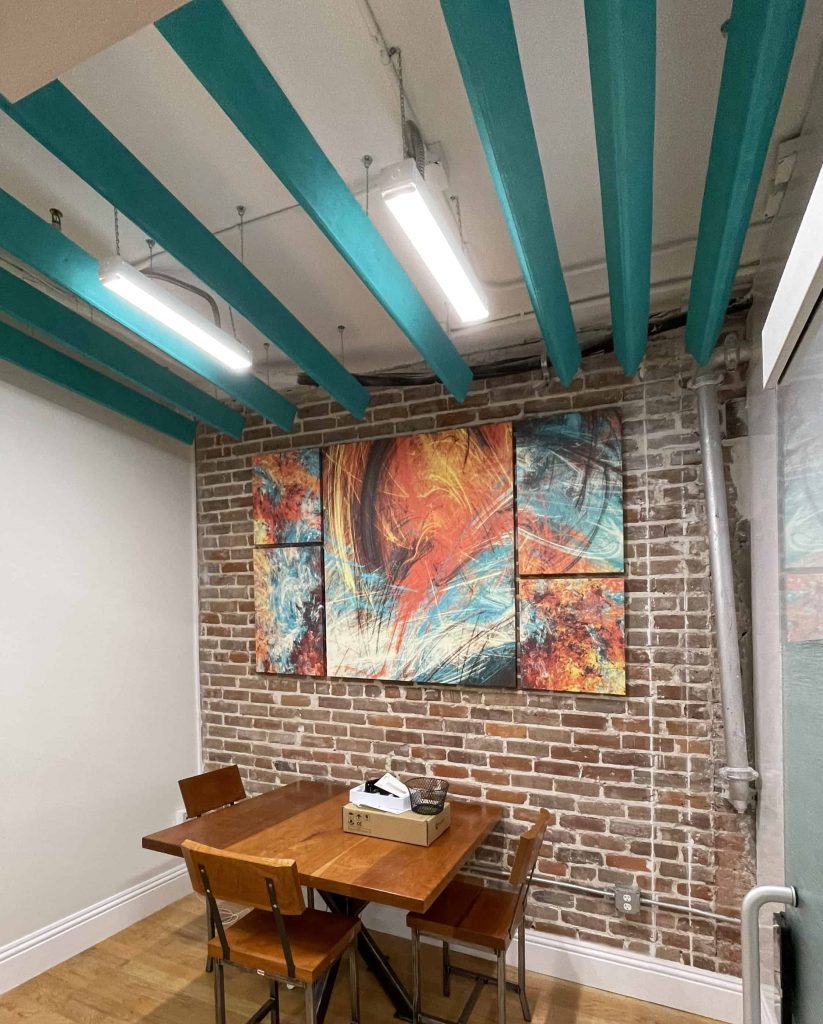 Brick wall office with bold abstract painting by My Favorite Art Place