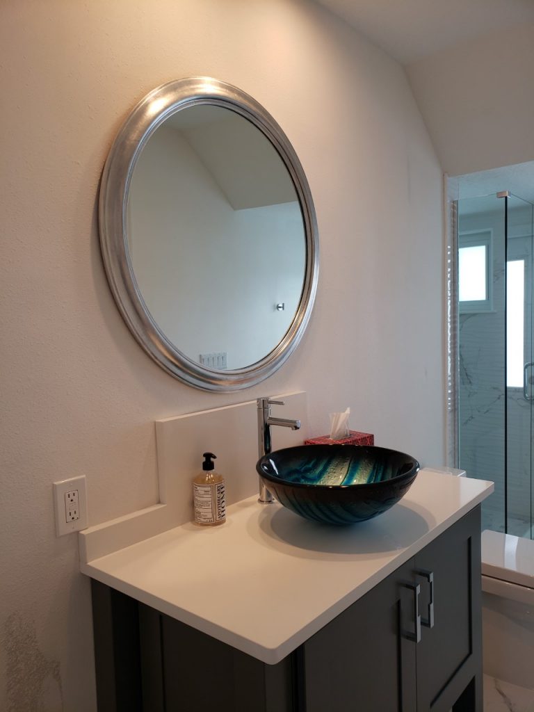 Round wall mirror above sink by My Favorite Art Place