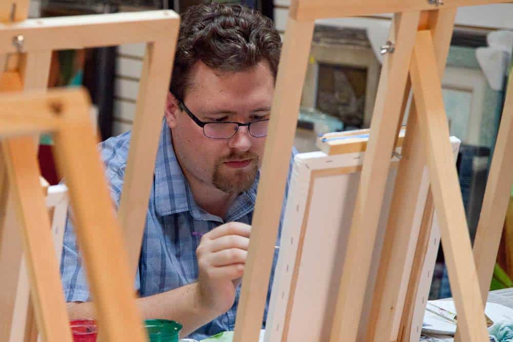 Artist painting on canvas at My Favorite Art Place workshop.