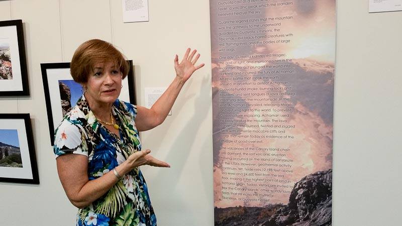 Art presentation at My Favorite Art Place showing a woman explaining a framed artwork during a gallery event.